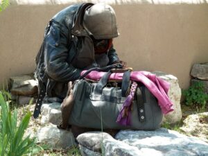 Homeless person huddled with belongings